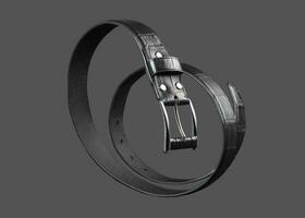 Black leather belt twisted in a spiral on a gray background. photo