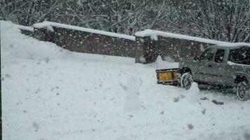 Snowfall on parking garage with snow plow clearing ice safely video