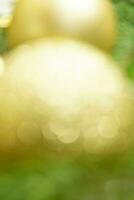 Defocused lights and blurred yellow-golden balls with green spruce with glowing background with soft focus. Merry Christmas and Happy New Year. Copy cpace photo