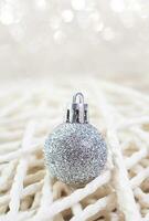 Christmas New Year's silver toy on background handmade from threads. Defocus bokeh, soft focus. Vertical. Copy space photo