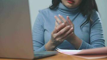 asiatico donna doloroso dito dovuto per prolungato uso di tastiera video