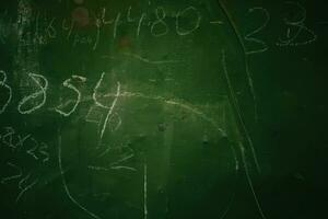 An old peeled green production board with numbers written in chalk. photo