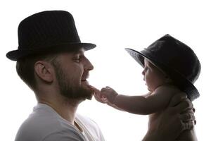 gracioso padre y niño en clásico sombreros en iluminar desde el fondo. padre y pequeño hijo. foto