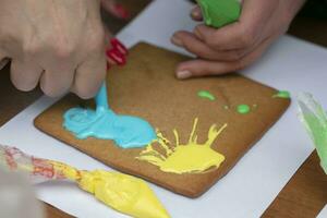 Hand draws on gingerbread with cream icing. photo