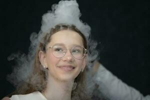 The child is a participant in scientific experiments. Girl in liquid nitrogen smoke. photo