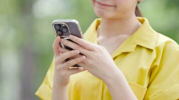 gelukkig schattig meisje gebruik makend van kaart toepassing Aan mobiel telefoon terwijl staand Aan modern stad achtergrond. video