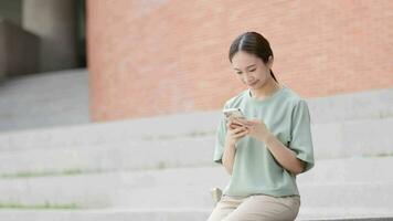 japonês mulheres sentado e falando em a telefone às universidade video