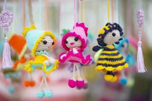 Small funny handmade knitted dolls are for sale at the craft fair. photo