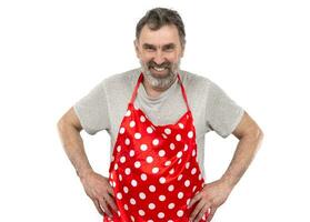 An elderly bearded man in a red polka-dot culinary apron on a white background. photo