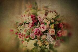 Old yellowed crumpled paper with a bouquet of multi-colored roses. Sheet of vintage notebook with flowers. photo