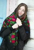 Portrait of a beautiful girl in a Russian headscarf. Young woman . Russian village in winter. photo