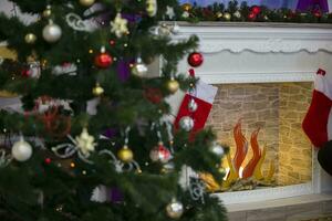 Fragment of a Christmas tree with toys on the background of an artificial fireplace.Christmas background photo