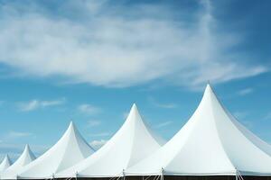 Row of white tent tops under a blue sky photo