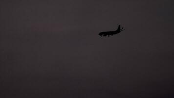 de vliegtuig Aan de laatste nadering voordat landen Aan de achtergrond van de zonsondergang schemer lucht video