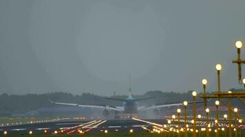 AMSTERDAM, THE NETHERLANDS JULY 27, 2017 - KLM Airbus A330 slows down after landing, rear view. Airplane braking against the background of bright landing lights at the Amsterdam airport AMS video