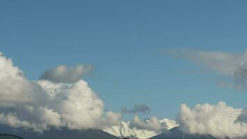las nubes se arremolinan sobre la cresta nevada. timelapse del movimiento de las nubes en las montañas. pintorescos peyzhas del cáucaso montañoso video