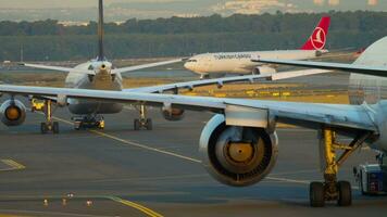 FRANKFURT AM MAIN, GERMANY JULY 21, 2017 - Lufthansa Airbus 330 D AIKD and Ethiopian Boeing 777 ET ANQ towing to service at sunrise, Turkish Cargo A330 at background. Fraport, Frankfurt, Germany video