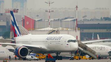 MOSCOW, RUSSIAN FEDERATION JULY 30, 2021 - Airbus A350 Aeroflot service by airport staff before departure, flight preparation. Airplane on Apron. Tourism and travel concept video