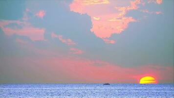 pôr do sol em a mar com pescaria barco e vermelho laranja amarelo nuvem fundo Tempo lapso video