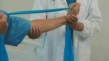 terapeuta tratando un masculino lesionado por rotador brazalete extensión método, físico terapia concepto. video