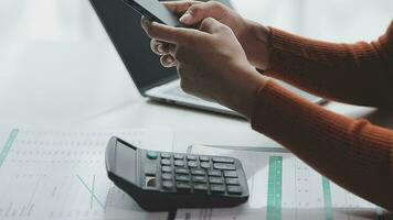 Asian Businesswoman Using laptop computer and working at office with calculator document on desk, doing planning analyzing the financial report, business plan investment, finance analysis concept. video