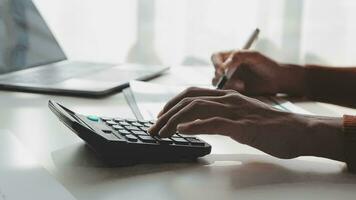 Asian Businesswoman Using laptop computer and working at office with calculator document on desk, doing planning analyzing the financial report, business plan investment, finance analysis concept. video