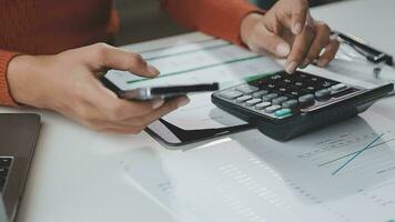 Asian Businesswoman Using laptop computer and working at office with calculator document on desk, doing planning analyzing the financial report, business plan investment, finance analysis concept. video