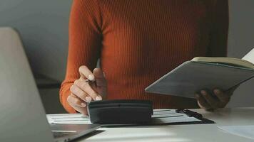 Asiatisk affärskvinna som använder bärbar dator och arbetar på kontoret med kalkylatordokument på skrivbordet, planerar att analysera den finansiella rapporten, affärsplansinvesteringar, finansanalyskoncept. video