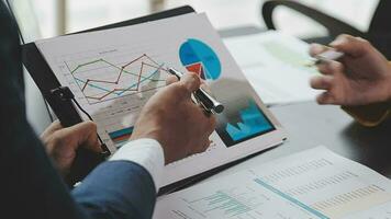 équipe commerciale financière présente. les mains de l'homme d'affaires tiennent des documents avec des photos de stock de statistiques financières, des discussions et des données de rapport d'analyse les tableaux et les graphiques. concept financier des finances video