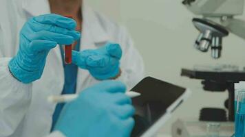 investigadores de atención médica que trabajan en el laboratorio de ciencias de la vida. joven científica investigadora y supervisora masculina senior preparando y analizando portaobjetos de microscopio en el laboratorio de investigación. video