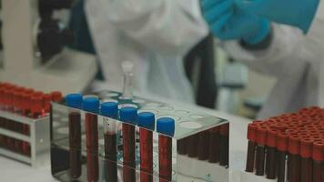 Health care researchers working in life science laboratory. Young female research scientist and senior male supervisor preparing and analyzing microscope slides in research lab. video