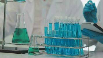 Health care researchers working in life science laboratory. Young female research scientist and senior male supervisor preparing and analyzing microscope slides in research lab. video