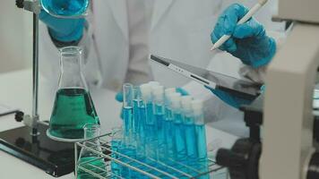 Health care researchers working in life science laboratory. Young female research scientist and senior male supervisor preparing and analyzing microscope slides in research lab. video