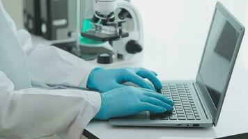 Health care researchers working in life science laboratory. Young female research scientist and senior male supervisor preparing and analyzing microscope slides in research lab. video