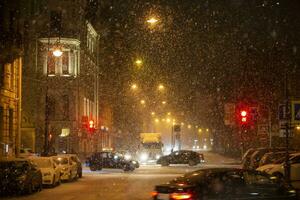 Snow-covered background of the night city with traffic lights and cars. photo