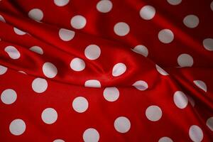 Red silk fabric with large white polka dots. Polka dot background. photo