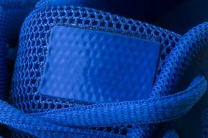 Fragment of a blue sneaker with drawstring macro.Sneaker texture photo