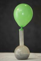 A rubber balloon is stretched over a chemical flask to demonstrate scientific experience. photo