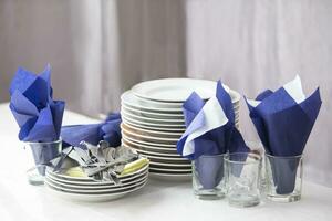 A stack of empty plates and napkins in a restaurant on a table. photo