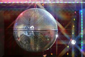 Disco ball with bright beams, night party background photo. photo