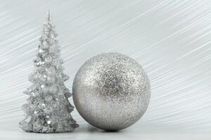 Christmas or New Year background with silver snowy tree and silver transitional decoration. Bright festive background. photo
