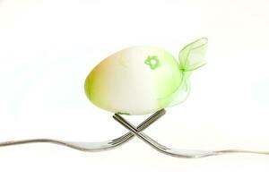 Easter egg kept on the cutlery on a white background photo