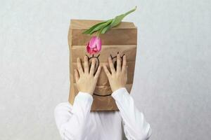 A paper bag with a painted smiling face on the child's head. The concept of an anonymous gift. photo