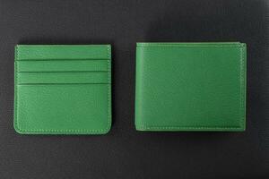 Leather products. Wallet business card holder made of green leather on a black background. photo