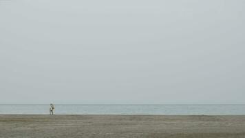 Couple having a walk on empty ocean beach video