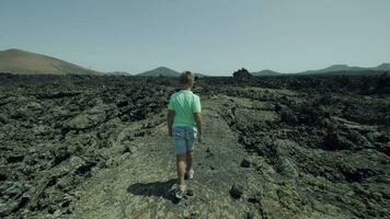 Garoto viajante explorando Lanzarote único natureza e escalada lava pedras video