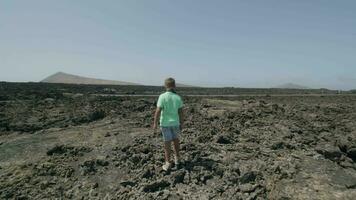 Suivant une garçon, en marchant à travers rocheux paysage video