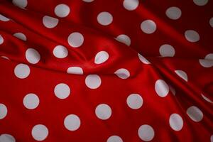 Red silk fabric with large white polka dots. Polka dot background. photo