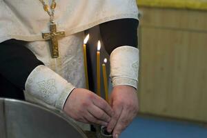 The rite of baptism. Priest prepare to baptize the child. Font for taking faith.The hands of the priest near the Epiphany bath photo