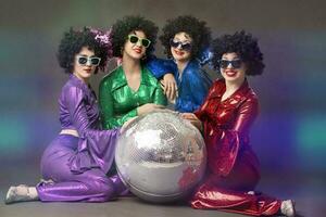 Group of happy girls in disco style, with disco ball, halloween party, on gray background. 80s themed party. photo